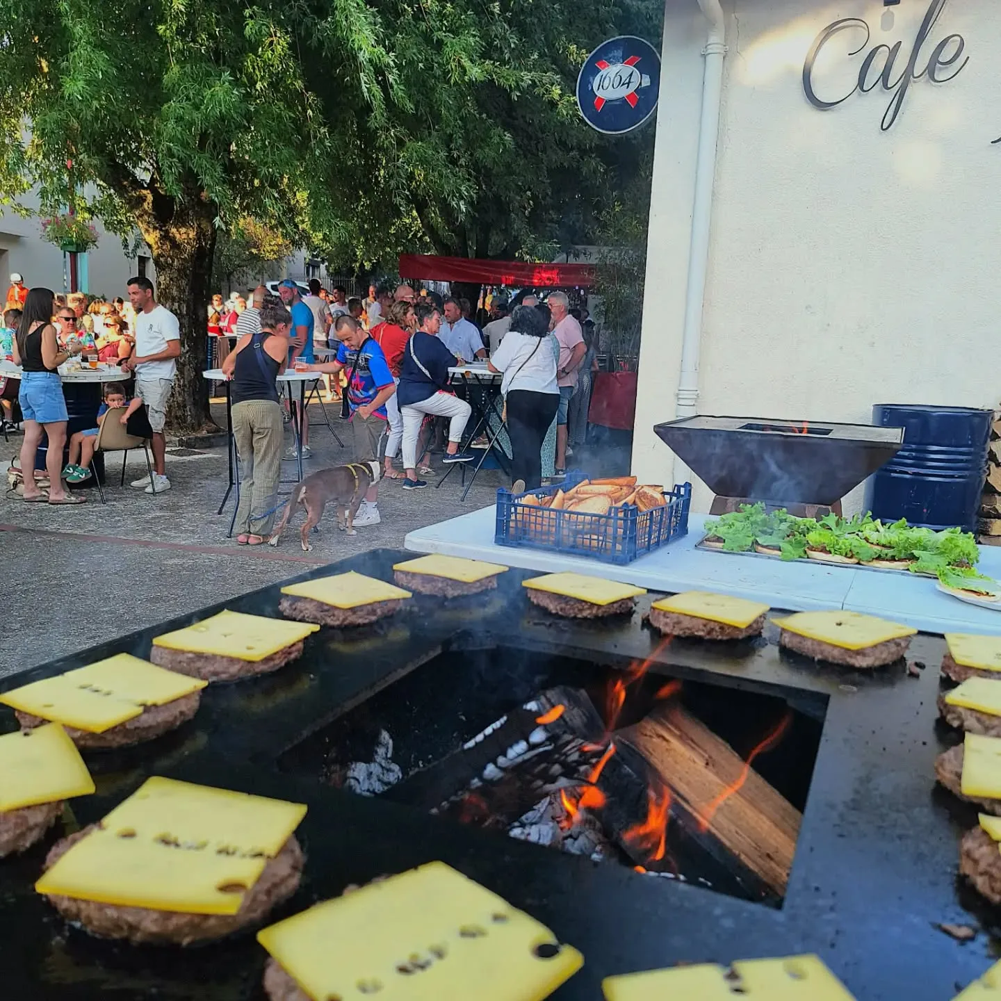 Cuisson de burgers au feu devant Chez Fab pendant une fête locale